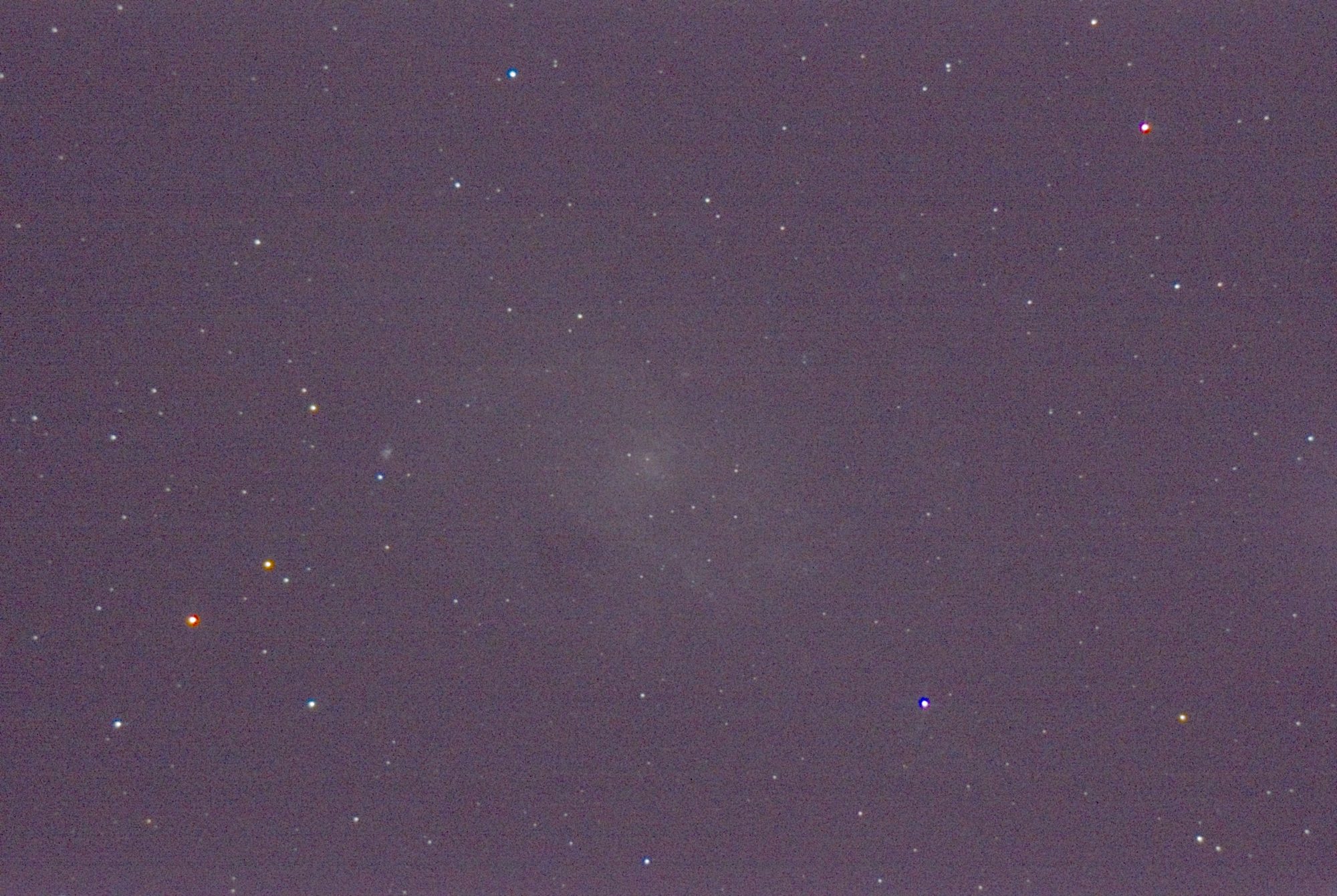 A single 10-second frame of the same field: grainy, the sky lifted, the galaxy barely there