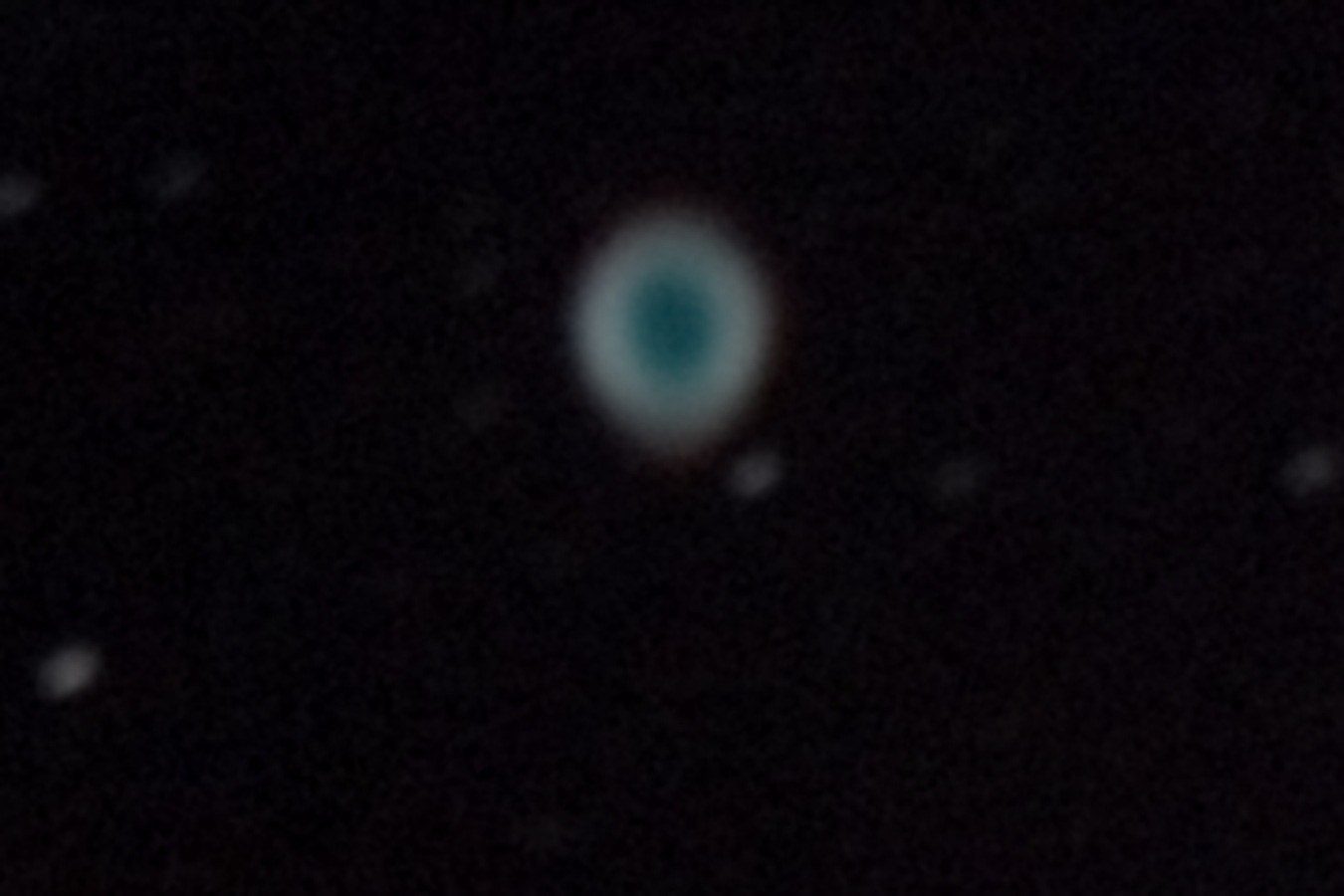 The Ring Nebula, a small blue-green ring with a darker centre